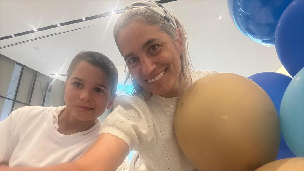 יעל נאמן, אלמנתו של ד"ר איתן נאמן שנפל במלחמה, עם הבן יהודה