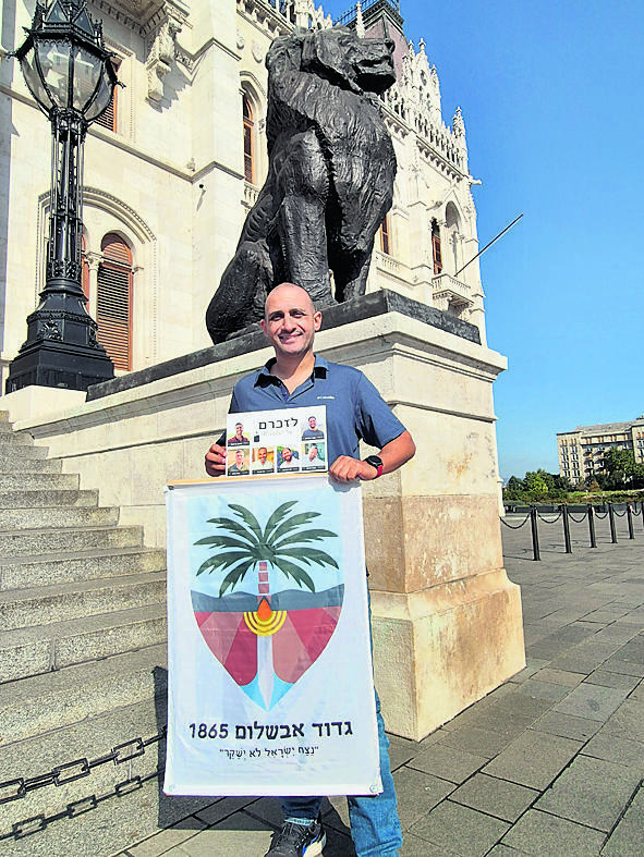 Eyal Korach (Photo: Lior Ben Ami) אייל כורח עם תמונות חללי הגדוד