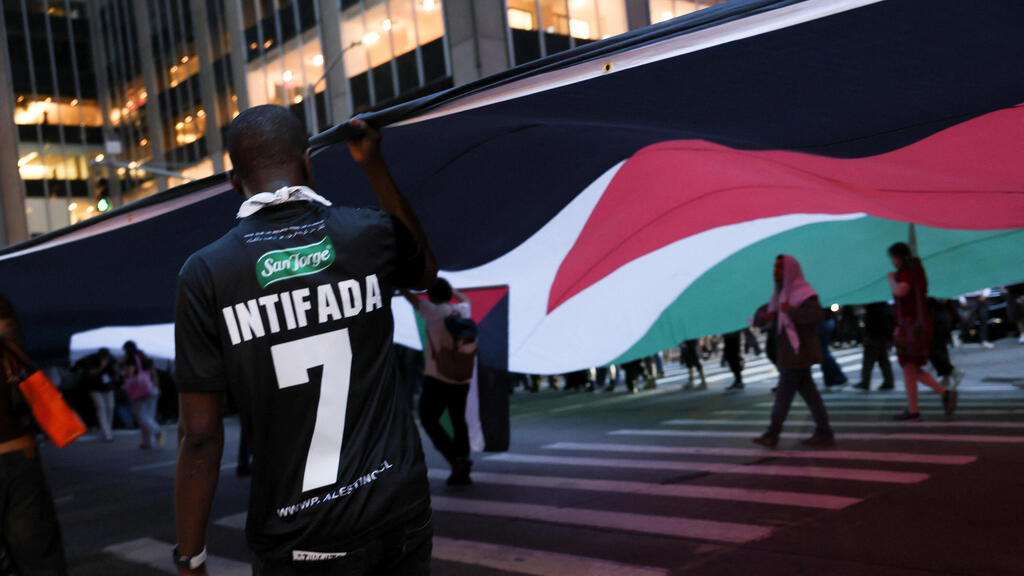 Photo: Shannon Stapleton/ Reuters מפגין אנטי-ישראלי עם חולצה הקוראת לאינתיפאדה, ביום השנה השני למתקפת הטרור של חמאס