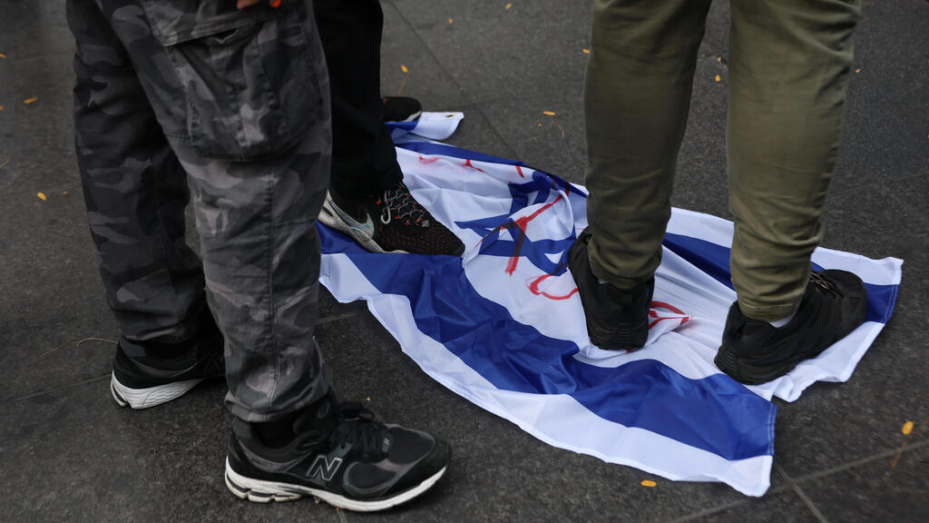 פעילים פרו-פלסטינים דורכים על דגל ישראל בניו יורק, ב-7 באוקטובר 2025