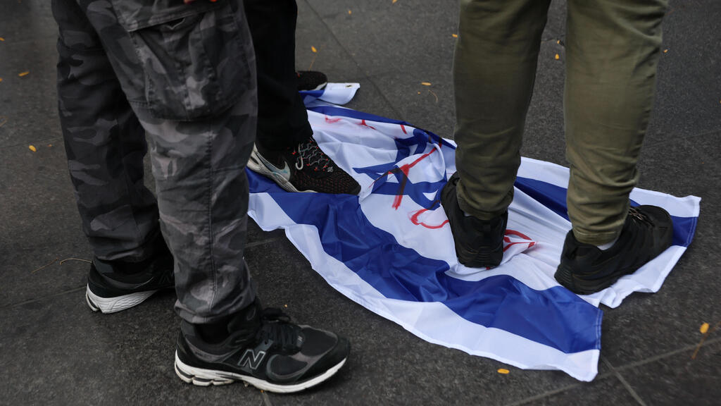 פעילים פרו-פלסטינים דורכים על דגל ישראל בניו יורק, ב-7 באוקטובר 2025