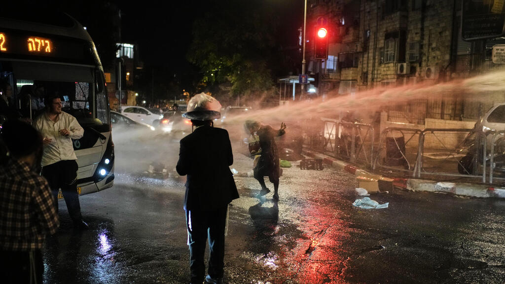 Полиция применила водомет (Фото: AP Photo/Leo Correa) עימות בין חרדים לשוטרים בשכונת מאה שערים