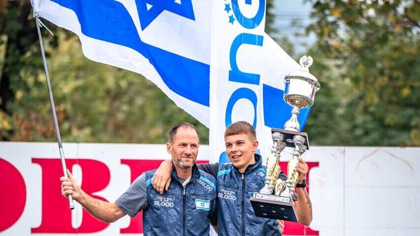 Эяль и его отец на подиуме (Фото: Shelby Wise) אייל ואביו עם דגל ישראל ברקע