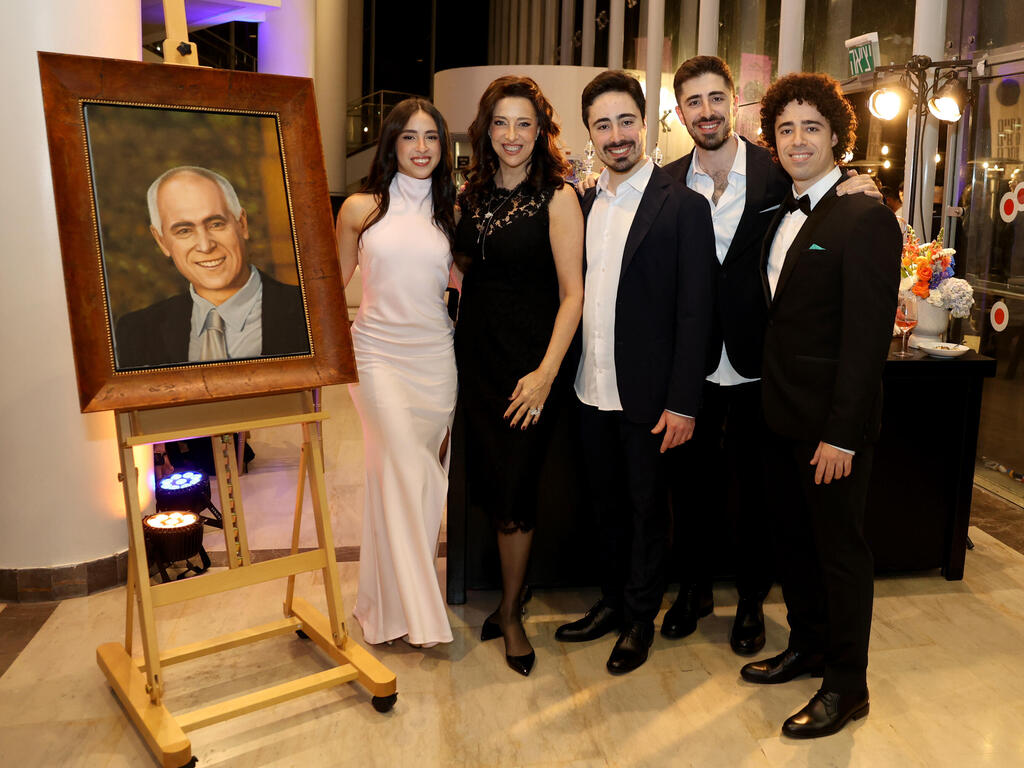 The Bublils next to a portrait of late father Moshe 