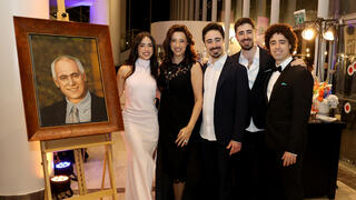 The Bublils next to a portrait of late father Moshe 