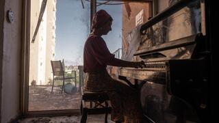 Woman plays piano in a kibbutz after the Oct 7 massacre 