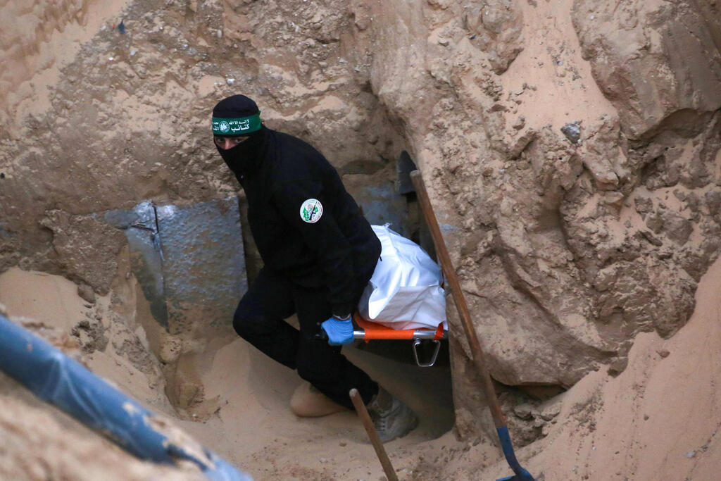 Hamas operatives recover remains of hostage in Khan Younis, Gaza (Photo: Bashar TALEB / AFP) מחבלי חמאס מחלצים לכאורה שרידים של חלל חטוף בשכונת חמד חאן יונס רצועת עזה