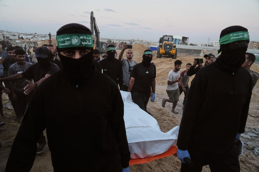 Hamas operatives recover body of Israeli hostage in Khan Yonis, Gaza (Photo: AP Photo/Jehad Alshrafi) מחבלי חמאס מחלצים לכאורה שרידים של חלל חטוף בשכונת חמד חאן יונס רצועת עזה