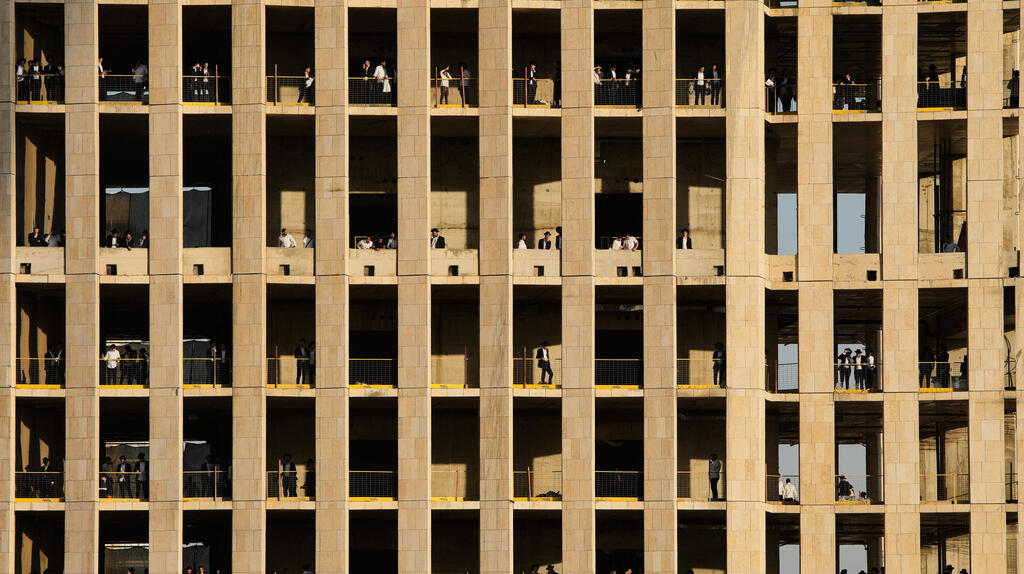 מפגינים צופים בעצרת משלד בניין באזור