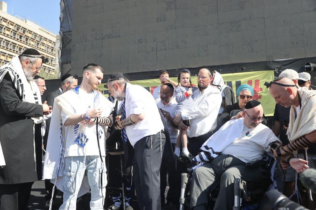 שורד השבי בר קופרשטיין הגיע לכיכר החטופים לאירוע הנחת תפילין