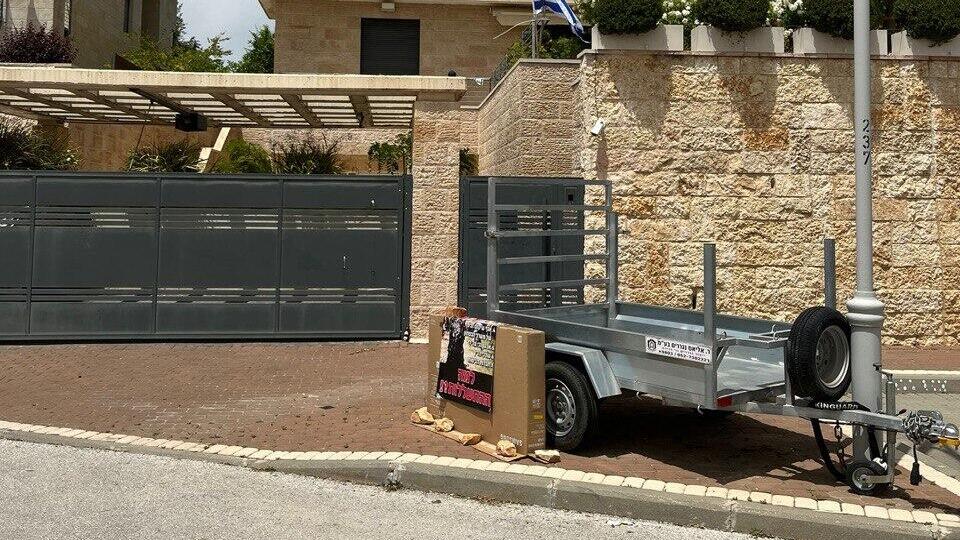 A trailer and protest sign left outside the home of a senior Rehabilitation Department official in Neve Ilan, Israel, Friday, Oct. 31, 2025. A former police officer suffering from post-traumatic stress disorder set himself on fire at the site earlier in the day המקום בו התגורר ויטל מישייב במשך שנה מול ביתה של ראש אגף השיקום, שם גם הצית את עצמו