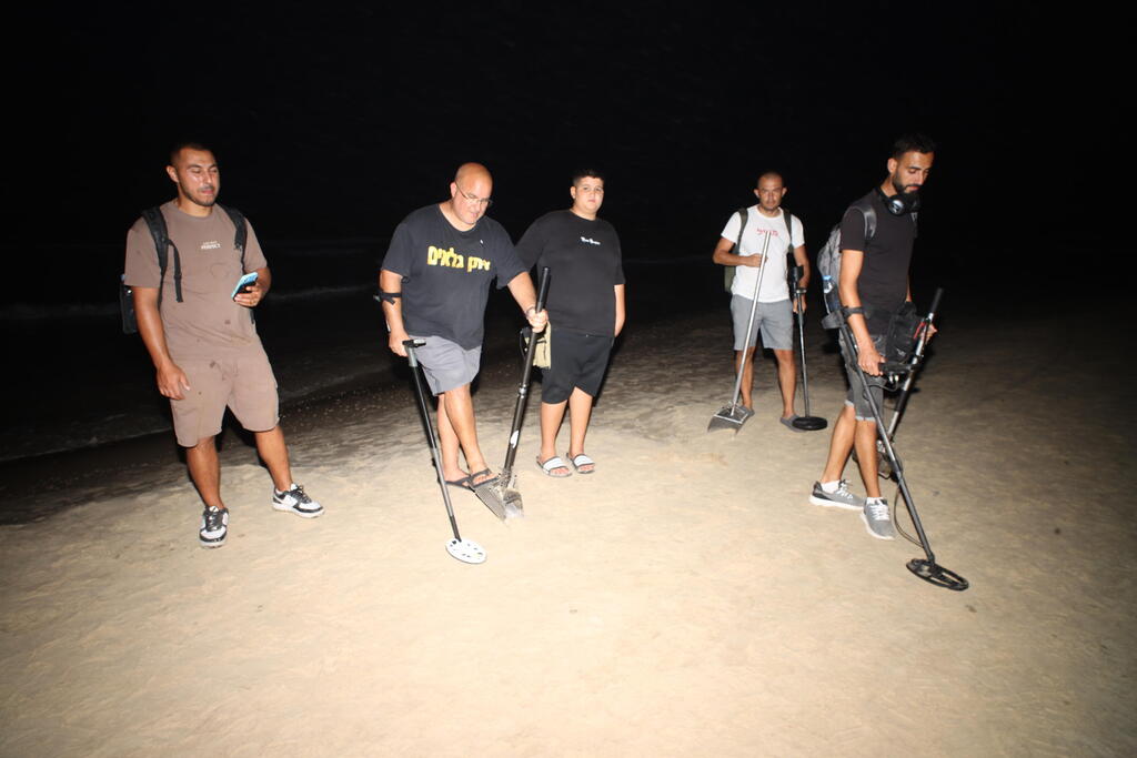 'Eitan Detectors' and peers searching for ex-military advocate general Yifat Tomer-Yerushalmi's missing cellphone along a beach strip in Herzliya (Photo: Yariv Katz) חיפושים עם גלאי מתכות אחר הטלפון של הפצר"ית בחוף השרון בהרצליה