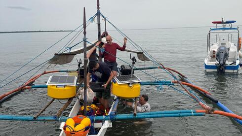 פרופ' רועי דיאמנט (לבוש בחולצה הלבנה במים) בעת הכנת מערכת האיכון בפיליפינים