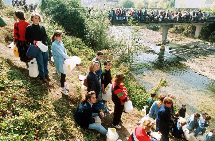 Bosnian civilians line up to collect water from a river near Sarajevo during the siege in the 1990s בוסניה סראייבו מצור מלחמה 1992