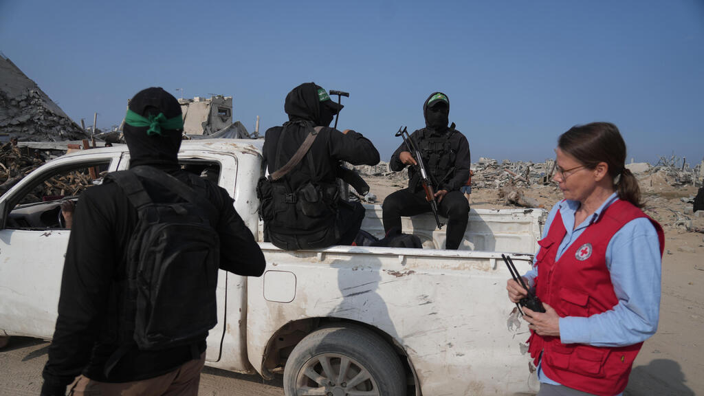 Боевики ХАМАСа с сотрудницей Красного Креста в секторе Газы (Фото: AP Photo/Jehand Alshrafi) חמאס והצלב האדום פועלים לאיתור חטופים חללים במזרח העיר עזה