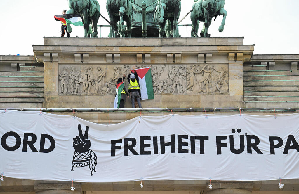 פעילים מפגינים פרו-פלסטינים על שער ברנדנבורג ברלין גרמניה