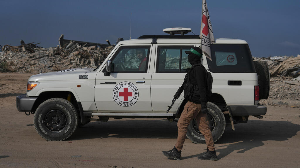 Боевик ХАМАСа возле машины Красного Креста (Фото: AP Photo/Jehand Alshrafi) חמאס והצלב האדום פועלים לאיתור חטופים חללים במזרח העיר עזה