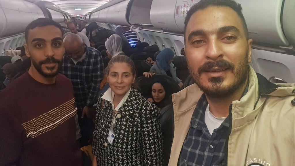 Палестинцы на борту самолета в Йоханнесбурге с послом ПА (Фото: REUTERS) חנן ג'ראר, שגריר פלסטיני בדרום אפריקה, עם העזתים שהגיעו ליוהנסבורג בטיסה