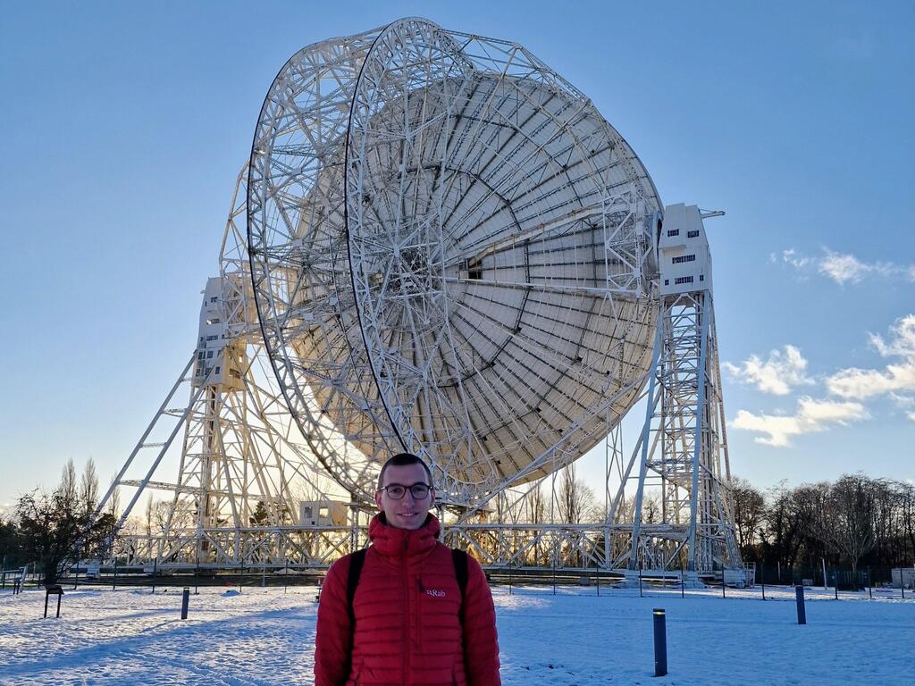 Lukas Böhme, who led the research team from Bielefeld University, with the Lovell Telescope (Photo: Bielefeld University) לוקאס במה, שהוביל את צוות המחקר מטעם אוניברסיטת בילפלד, ברקע טלסקופ לאבל שבמצפה הכוכבים ג'ודרל בנק - מצפה הכולל כמה מתקני רדיו-טלסקופ