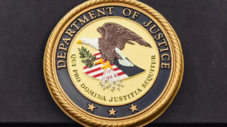 Department of Justice logo is seen on a podium during a press conference at the U.S. Attorney's Office in New York