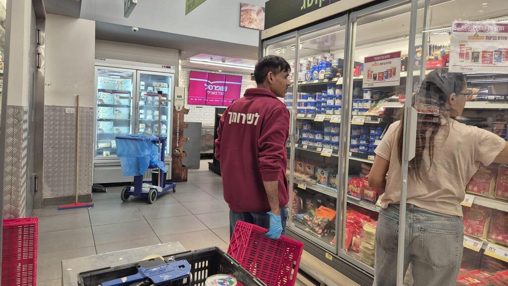 Иностранный работник в супермаркете (Фото: Мейрав Кристал) עובד זר בשופרסל