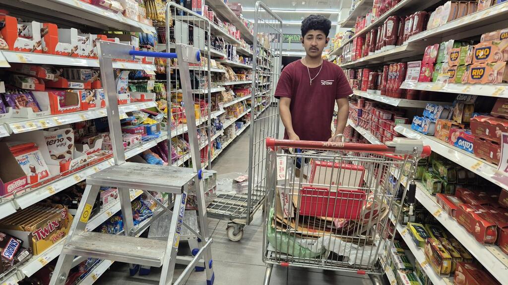 Иностранный работник в супермаркете (Фото: Мейрав Кристал) עובד זר בשופרסל