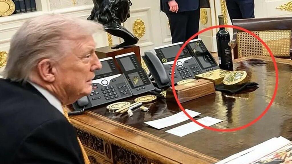 Дональд Трамп за рабочим столом. В красном кружке - золотой слиток и часы Rolex (Фото: пресс-служба Белого дома) מטיל הזהב והרולקס