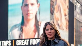 עדן שמואל ניצולה מטבח מסיבת הנובה עם תמונתה על גבי בילבורד ב"טיים סקוואר", ניו יורק