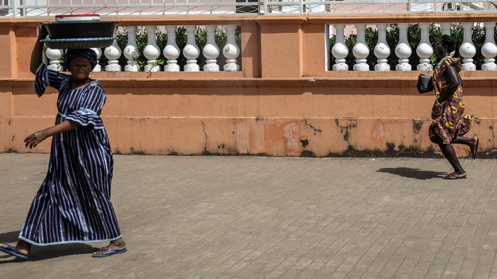 גינאה ביסאו הפיכה אישה בורחת מזירת ירי ליד ארמון הנשיאות ב ביסאו