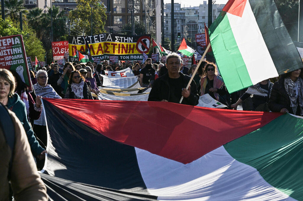 Pro-Palestinian protesters demonstrate outside the Israeli Embassy in Athens, Greece (Photo: Aggelos NAKKAS / AFP) מפגינים פרו פלסטינים הפגנה מחוץ ל שגרירות ישראל ב אתונה יוון