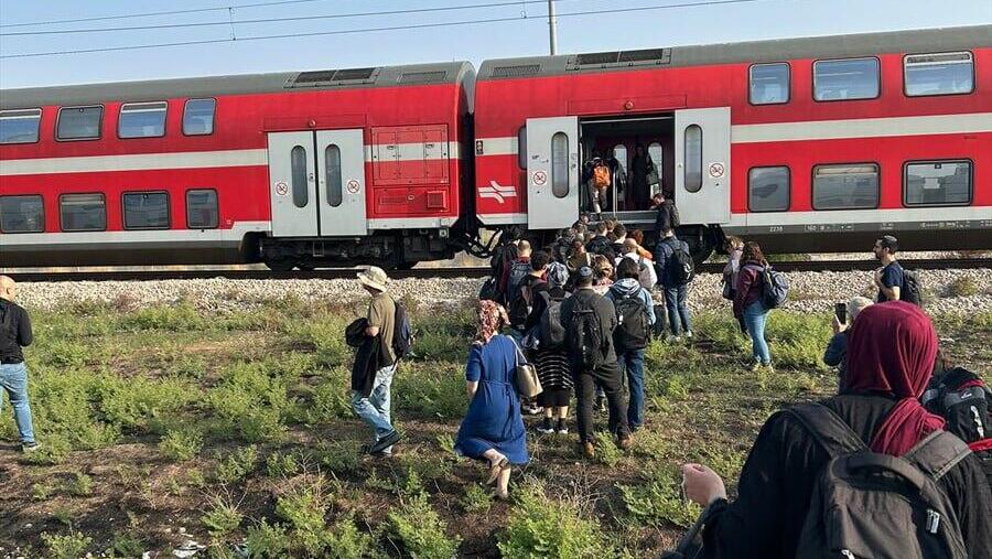 נוסעים עוזבים את קרון הרכבת שעצרה  באמצע הדרך