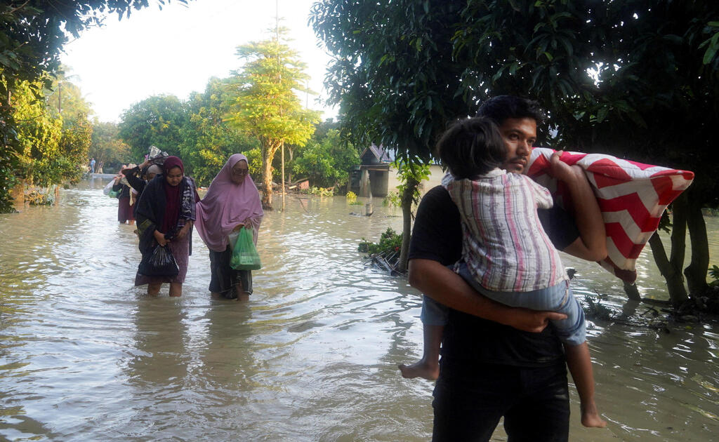 Жители выбираются из затопленных домов (Фото: REUTERS/Hendri) פינוי תושבים סומטרה אינדונזיה הצפות שיטפונות