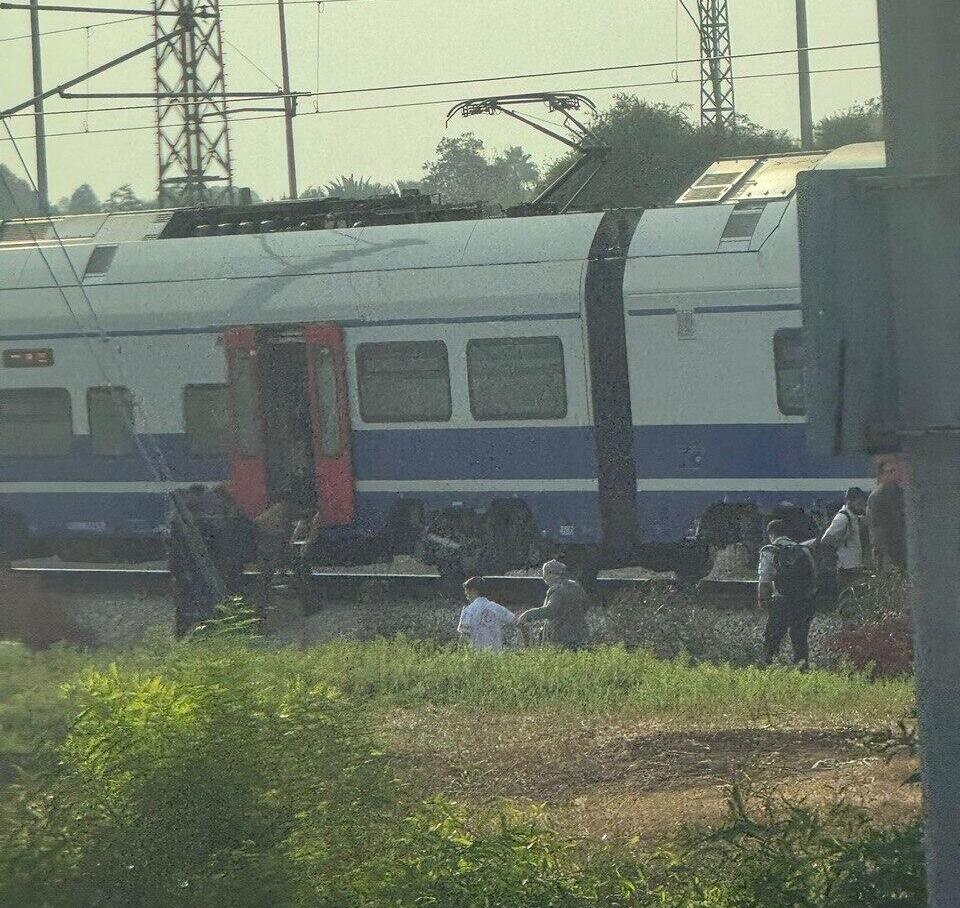 Passengers being let off trains and walking along the tracks to board a replacement train on an adjacent line נוסעים עוזבים את קרון הרכבת שעצרה באמצע הדרך