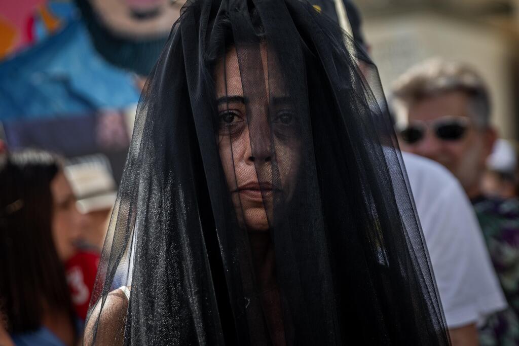 Einav Tsangauker dons a black veil during a symbolic wedding ceremony at Hostages Square in a desperate call to free her son, Matan. The event included Matan's partner, former hostage Ilana Gritchovsky. On October 13, after 738 days of relentless public advocacy, Matan was freed and Einav was finally able to embrace him upon his return from captivity, after the first phase of U.S. President Donald Trump’s 20-Point Plan to end the war was implemented. (Tel Aviv, August 17, 2025) (Photo:Shir Torem, Reuters) בקריאה נואשת לשחרור בנה החטוף מתן צנגאוקר עטתה עינב צנגאוקר הינומה שחורה במהלך טקס חתונה מבוים שנערך בכיכר החטופים בהשתתפות בת זוגו של מתן, שורדת השבי אילנה גריצ'ווסקי. תל אביב, 17 באוגוסט 2025