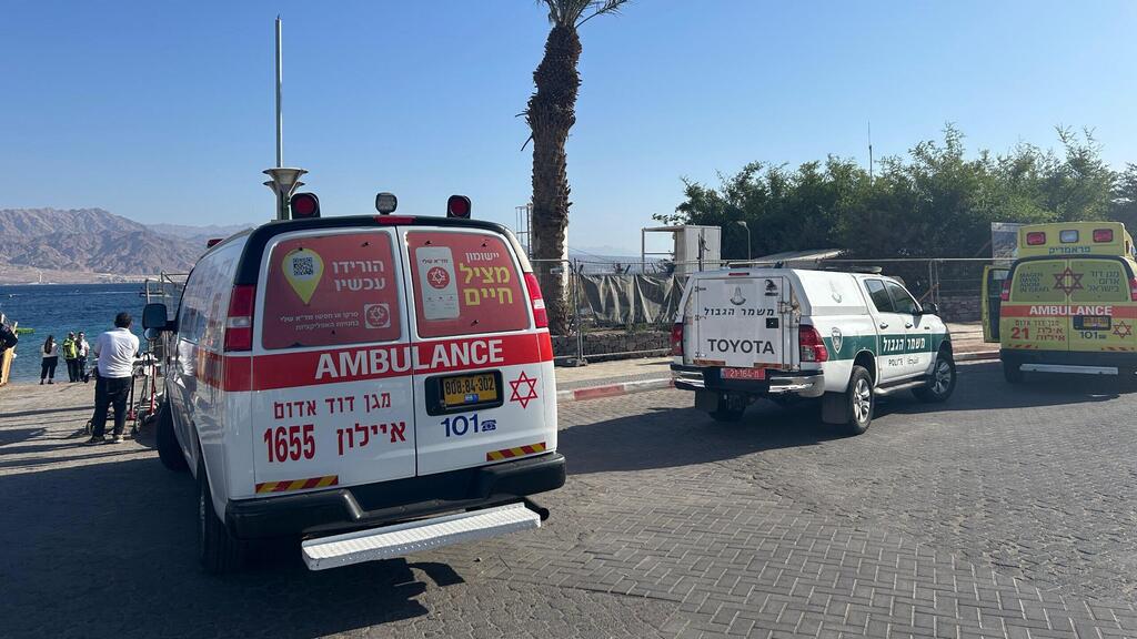 Машины полиции и скорой помощи возле места происшествия (Фото: оперативная съемка МАДА) רכב שהתדרדר למים סמוך לחוף הדקל באילת