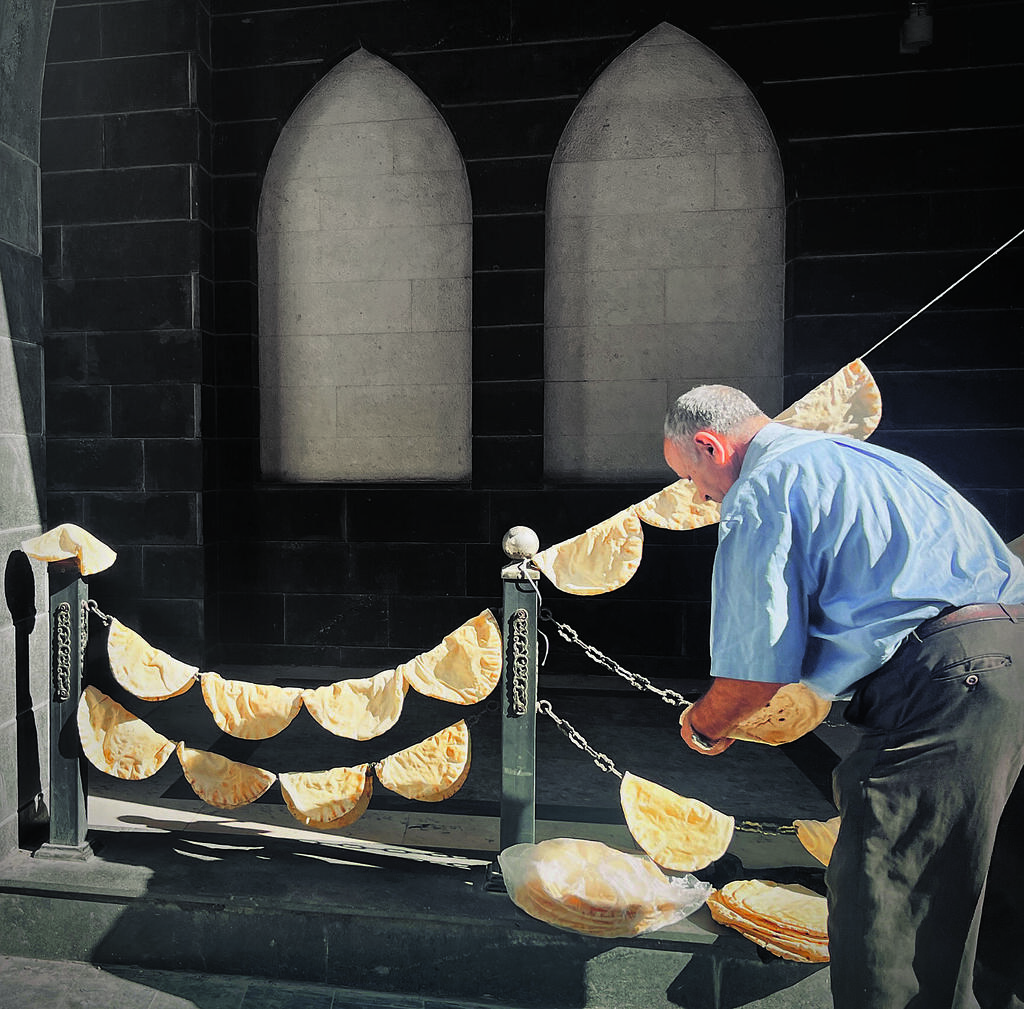 A man hangs flatbread to dry in Damascus. With food costs soaring and electricity scarce, residents rely on improvised methods to preserve staples 