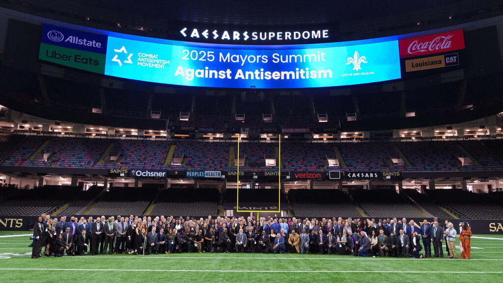 The mayors pose on the field of the Superdome, home of the New Orleans Saints (Photo: Paul Morse Photography) תמונה קבוצתית באיצטדיון של משתתפי הכנס