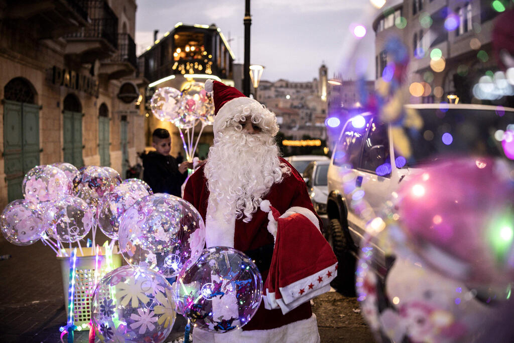 A man dressed as Santa Claus sells balloons near Nativity Square during a Christmas tree lighting ceremony in Bethlehem, West Bank, on December 6, 2025 (Photo: JOHN WESSELS / AFP) A man dressed as Santa Claus sells balloons near Nativity Square during a Christmas tree lighting ceremony in Bethlehem, West Bank, on December 6, 2025