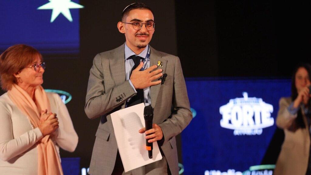 Former hostage Rom Braslavski is welcomed to the stage at the Atreju conference in Italy רום ברסלבסקי בכנס "אטרייו", היום