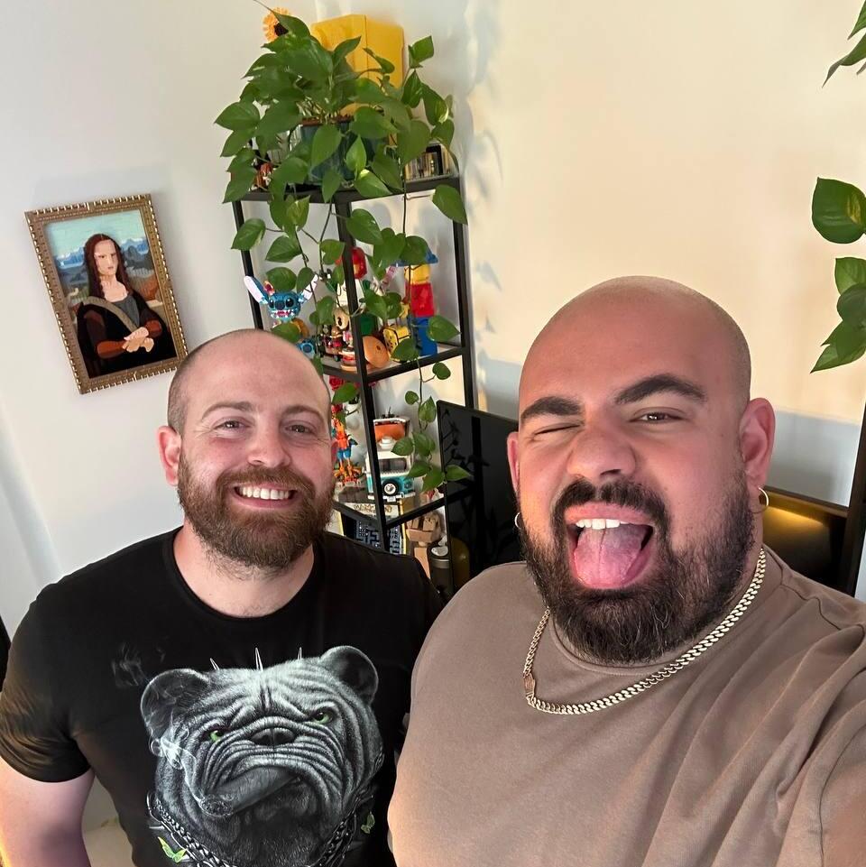 Bar Gindy, host of the People & Collectors podcast, left, poses for a photo with Lego collector Gal Zahavi at Zahavi’s home, where shelves of Lego models and plants line the wall 