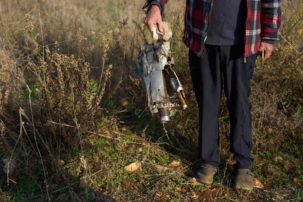 Ilan Rosenfeld holds a piece of a rocket fired by Hezbollah in his burnt-out business in Israel's northernmost town of Metula, Sunday, Nov. 30, 2025 (Photo: AP Photo/Ariel Schalit) Ilan Rosenfeld holds a piece of a rocket fired by Hezbollah in his burnt-out business in Israel's northernmost town of Metula, Sunday, Nov. 30, 2025