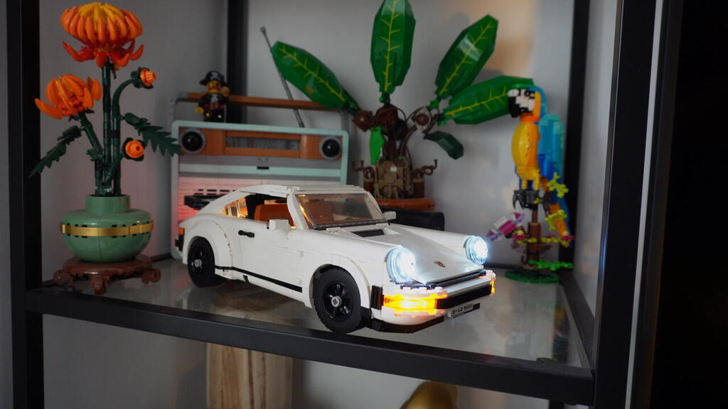  A Lego model of a white Porsche sports car is displayed alongside other Lego builds and decorative pieces in the home of collector Gal Zahavi 