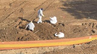 עובדים לבושים בסרבלי מיגון, מסכות נשימה וכפפות, כמתחייב בעבודה עם אזבסט, עוסקים במיון החול ומוציאים ממנו שברי אזבסט