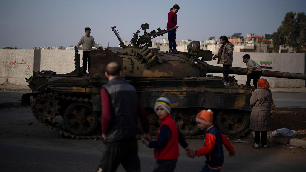 Children on the top of an ousted Syrian government forces tank that was left on a street in an Alawite neighborhood (Photo: AP) Syria Alawite women