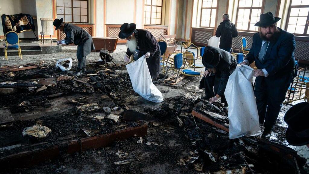 Gathering the holy books burned in the arson attack (Photo: Yehoshua Fruchter and Meir Zelznik) אוספים את שרידי ספרי הקודש