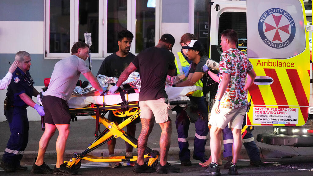 Evacuation of the injured in the mass shooting at Bondi Beach in Sydney Australia (Photo: Mark Baker/AP) פינוי הפצועים בירי ההמוני בבונדיי ביץ' באוסטרליה