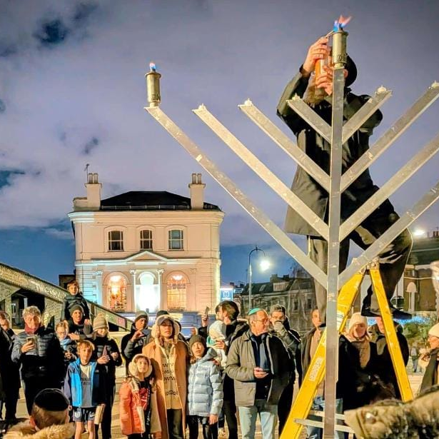 Зажигание свечи в еврейском квартале Лондона (Фото: Еврейская община Лондона) מדליקים נרות חנוכה בלונדון