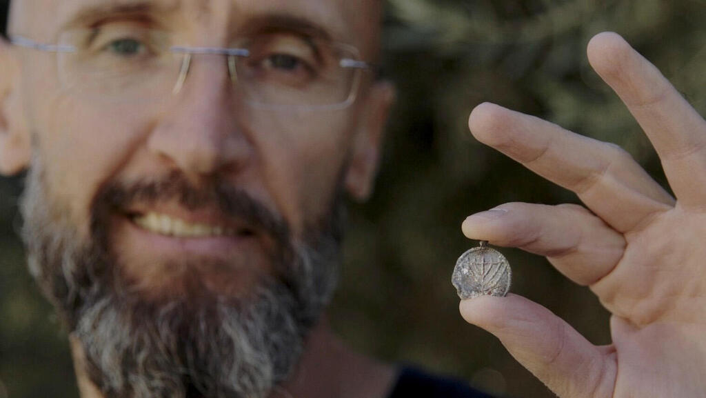 Dr. Philip Vukosavovic (Photo: Emil Aljam, Israel Antiquities Authority) ד"ר פיליפ ווקוסבוביץ מרשות העתיקות עם תליון המנורה