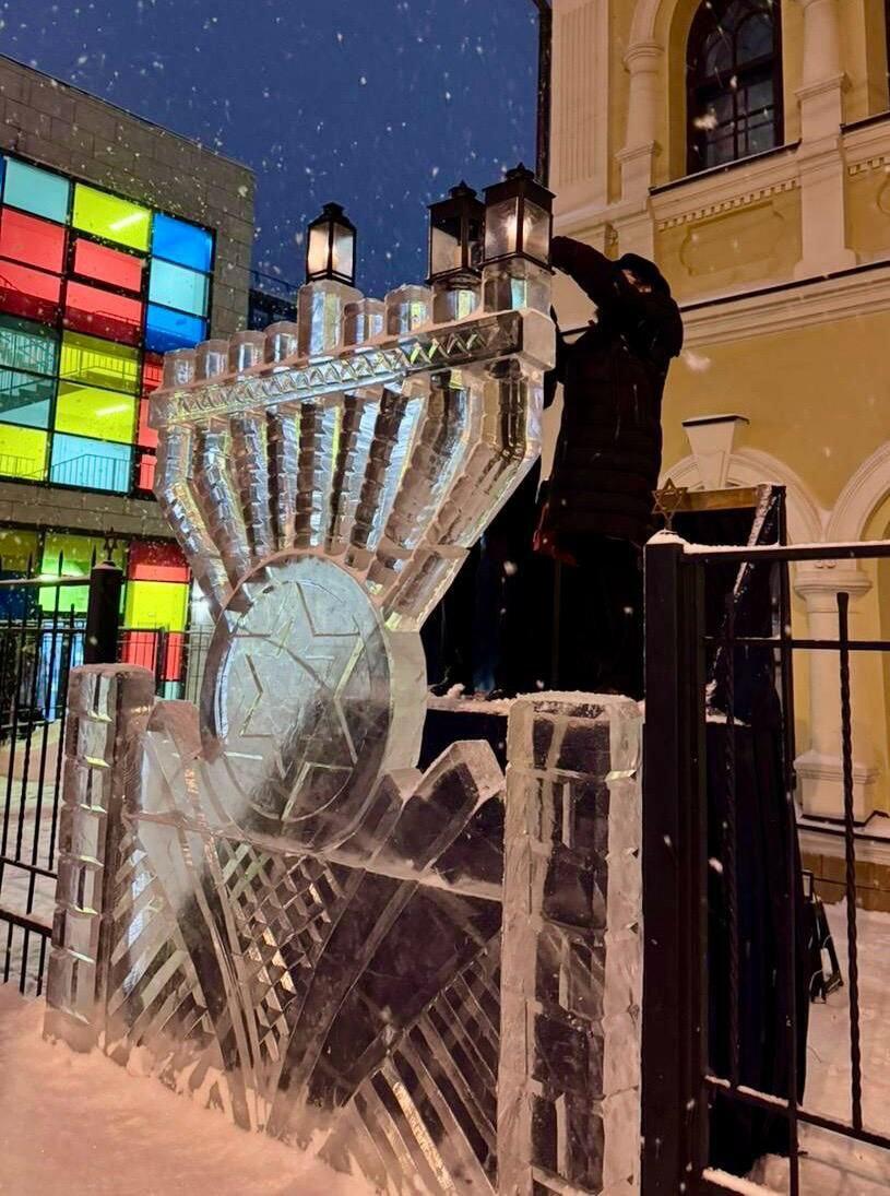 A menorah made of carved blocks of ice (Photo: The Jewish community in Tomsk) הדלקת נר שני של חנוכה בחנוכיית הקרח בסיביר