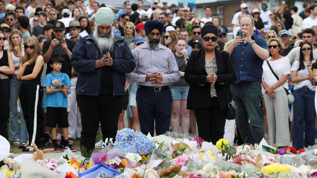 Paying respects to Bondi Beach victims (Photo: Hollie Adams/Reuters) אוסטרליה